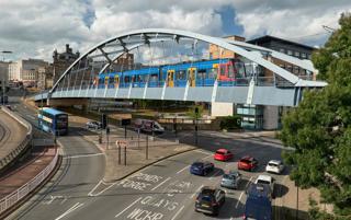 A train… straight into town. That’s the promise of tram-train, and one that more UK cities are interested in adopting. A Stadler Class 399 crosses the bowstring bridge over Park Square and Commercial Street in Sheffield. ALAMY.