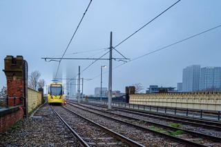 A Bee Network tram on its way out from Deansgate Castlefield in Manchester. ALAMY
