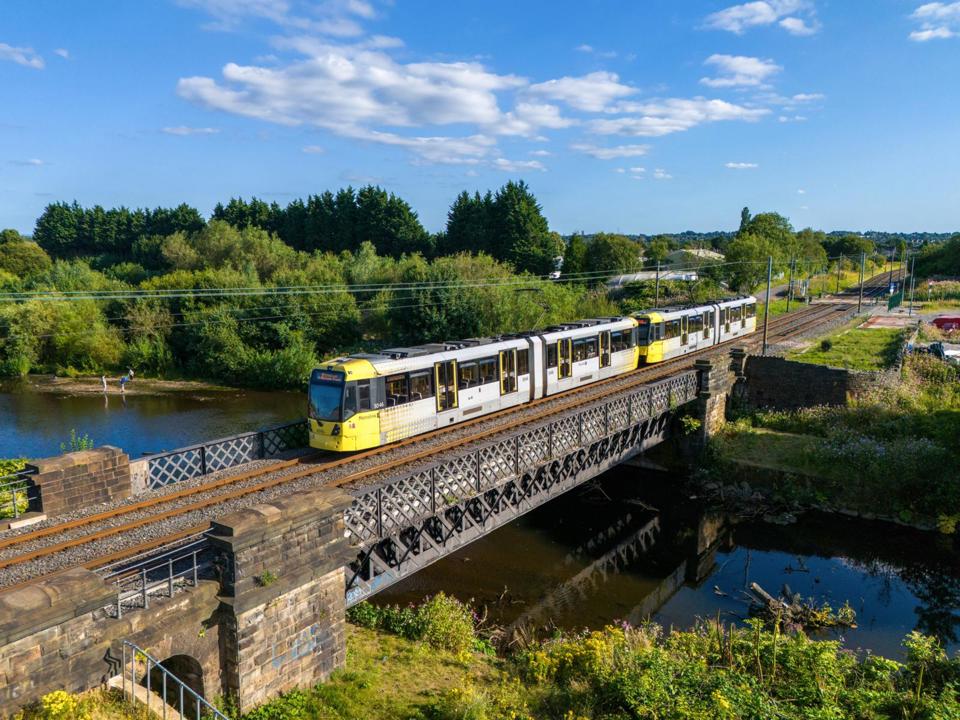 Manchester has been favoured by the government, with transport plans including a Metrolink extension to Stockport and new tram stops. Longer two-car trams to reduce the double-heading of the ‘M5000’ Bombardier/Alstom units has also been suggested locally. In such a formation, Metrolink Trams 3046 and 3047 cross the River Irwell on August 11 2004, approaching Radcliffe with a Bury to Altrincham service. TOM MCATEE.