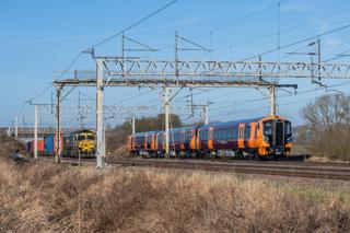 Paths are in short supply on the heavily used mixed-traffic West Coast Main Line. At Great Bridgford (Staffordshire) on January 26 2022, West Midlands Railway 730005 works along the West Coast Main Line on test as part of the fleet’s introduction to service, while Freightliner 66520 works an intermodal service. JACK BOSKETT.