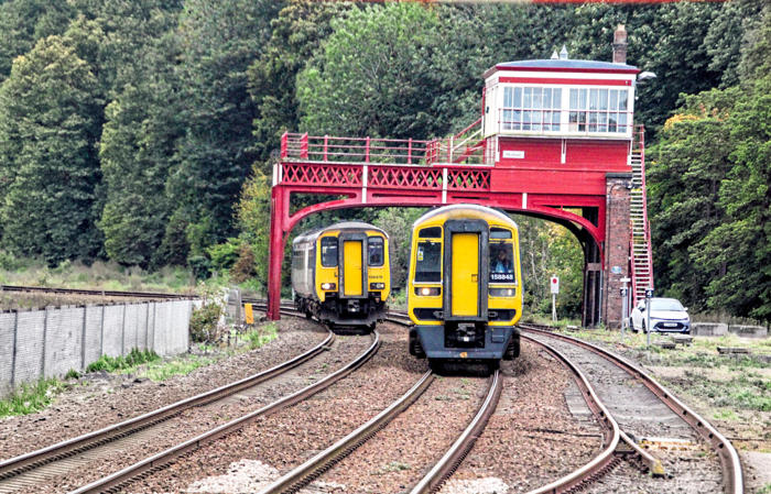 Northern 158848 and 156479 pass under the Victorian signal box at Hexham on October 11 2025. JAMES GROUNDWATER 