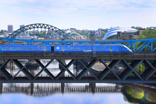Lumo service passes over Newburn Bridge with the Tyne Bridge in the background in Newcastle