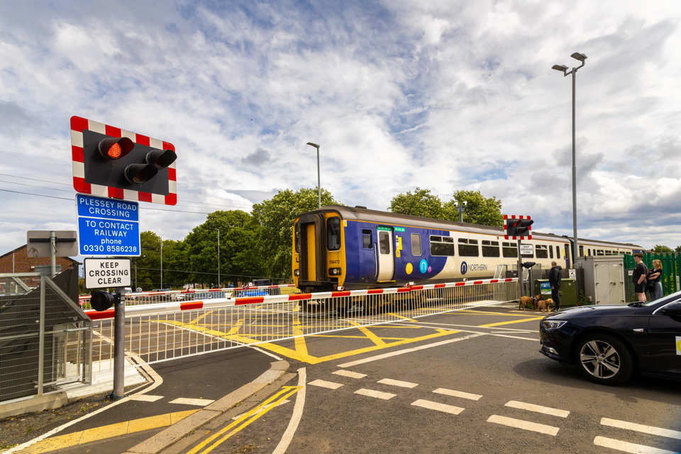 Northern 156472 passes a level crossing on the Northumberland Line. NORTHERN.