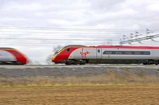 Two Virgin Pendolinos pass each other on the West Coast Main Line near Rugby. ALAMY.