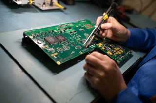 A circuit board with an engineer working on it